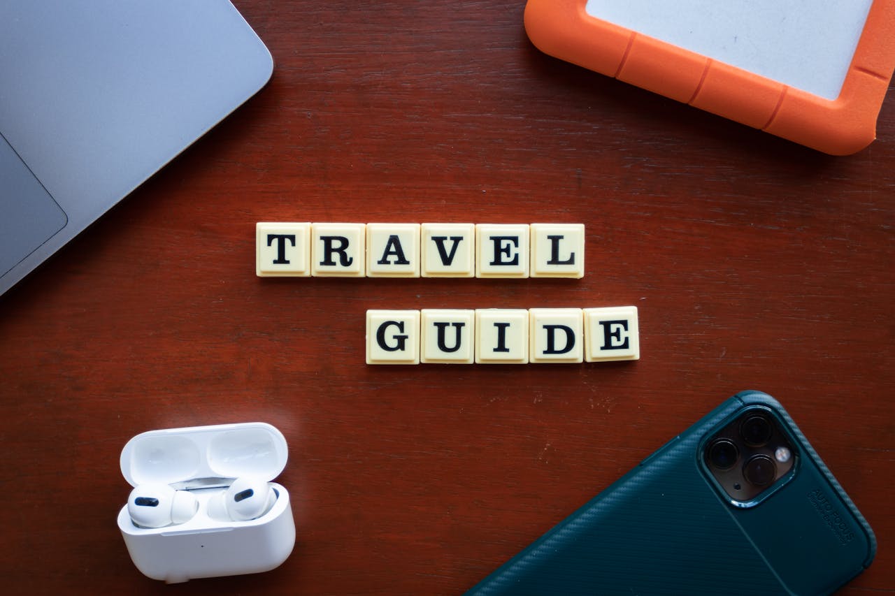 services-03 Flat lay of travel guide concept with smartphone, laptop, and headphones.