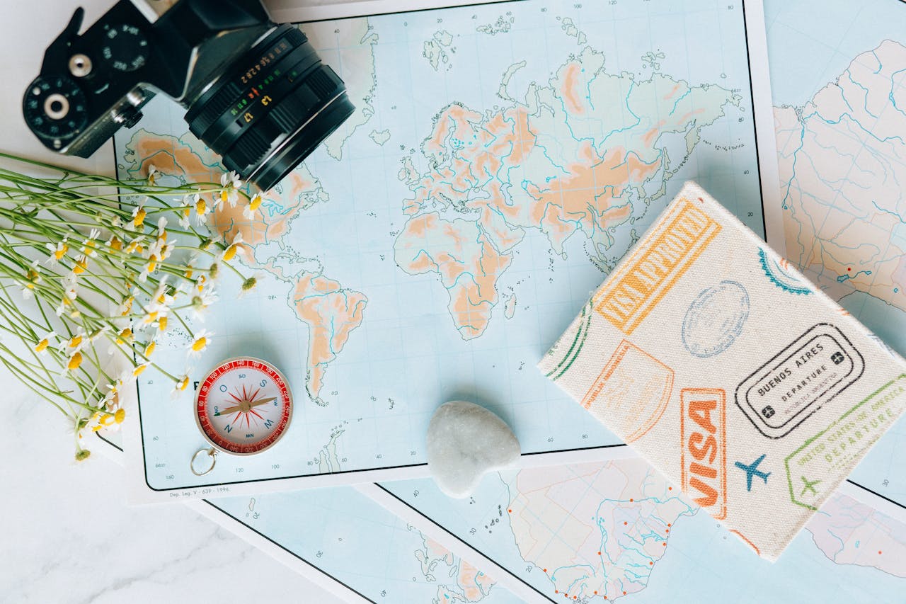 who-we-are Flat lay of travel essentials: maps, camera, compass, and travel journal for planning adventures.